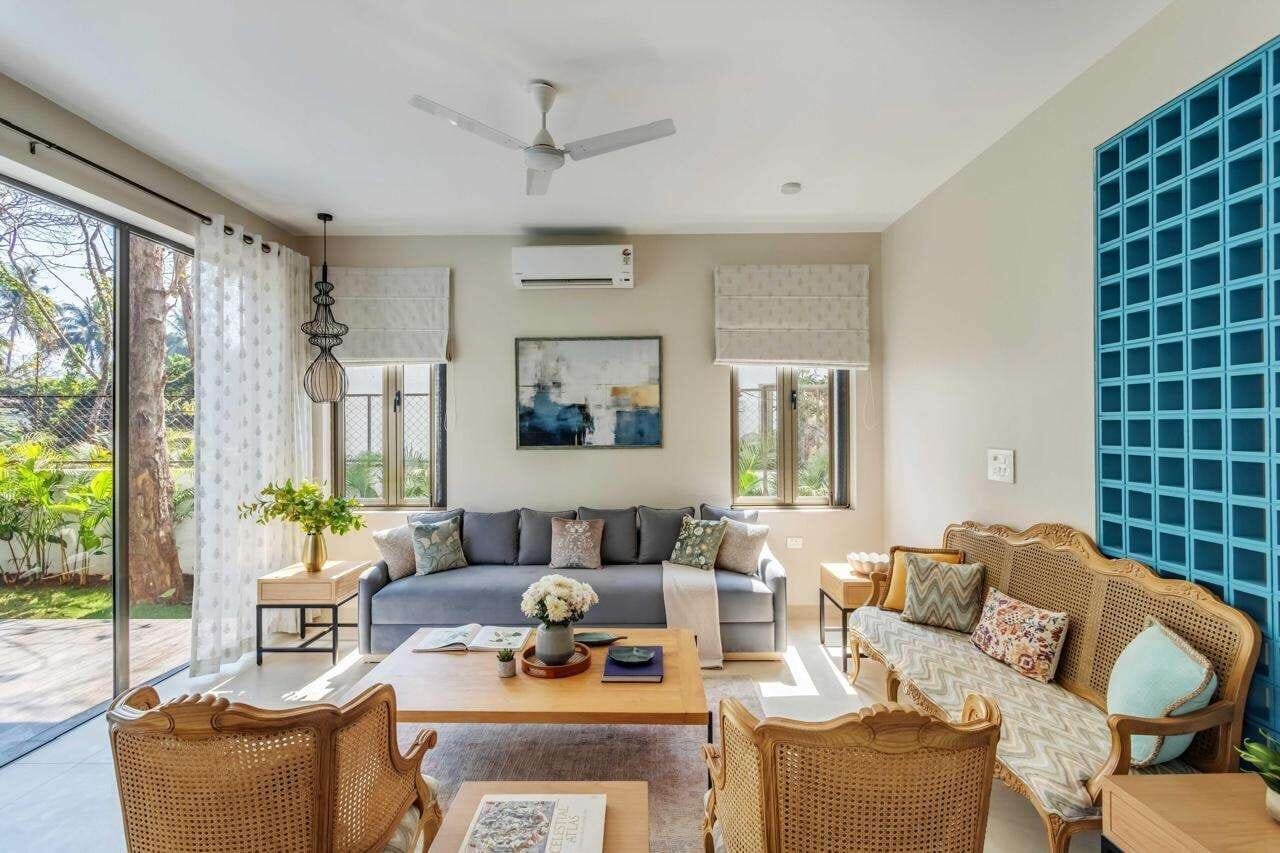 Villa living room with rattan armchairs and blue glass-block feature wall