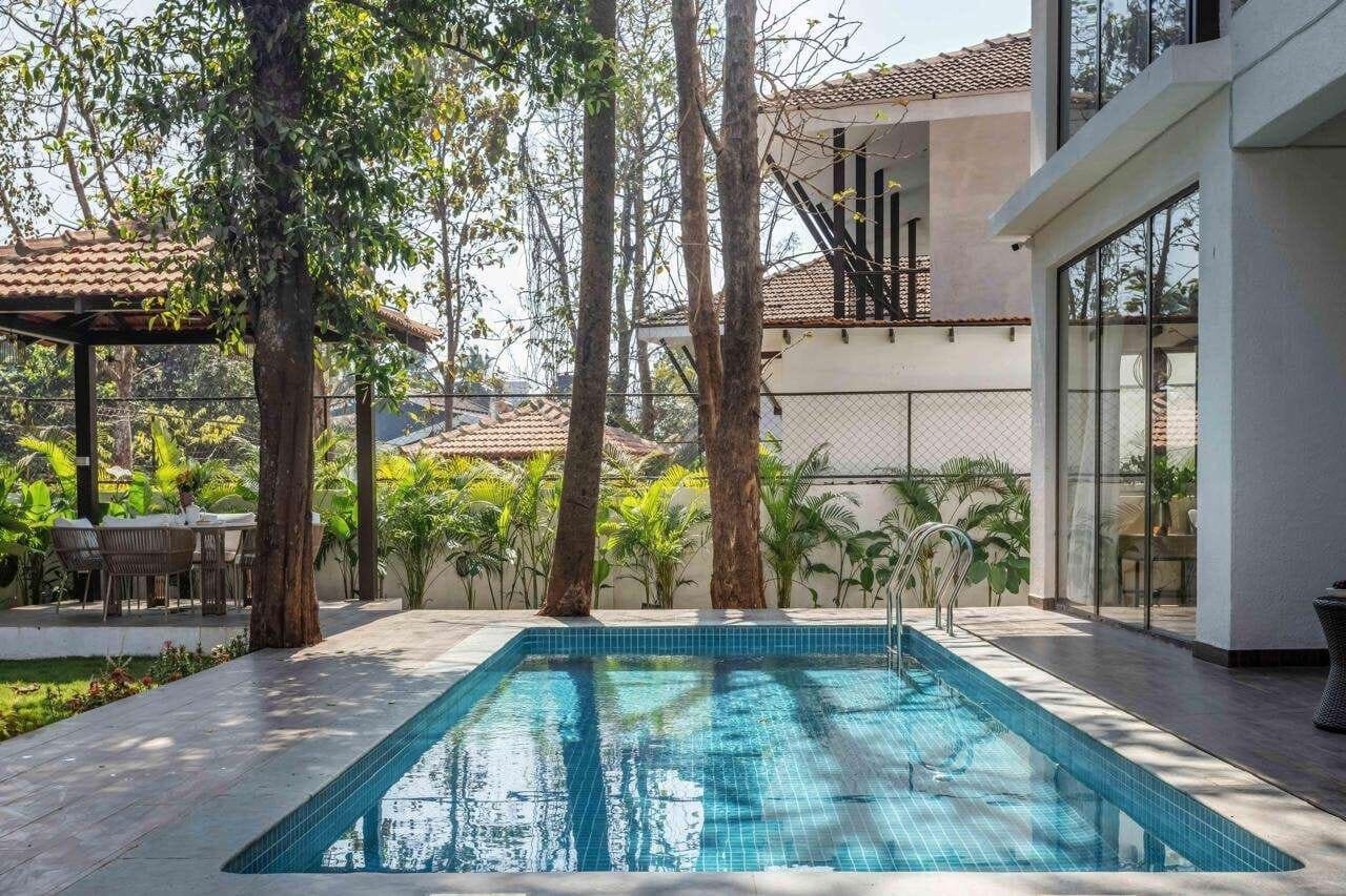 Villa exterior with pool, palm trees and covered dining pavilion