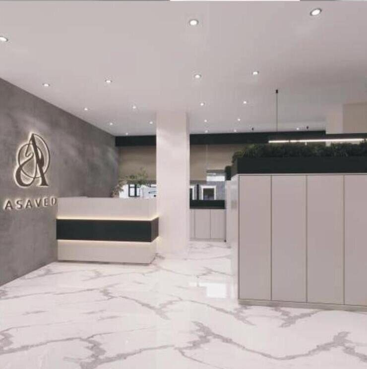Reception desk with backlit signage and marble flooring